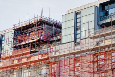 construction site with scaffolding surrounding modern buildings 4 construction methods safety 4 progress