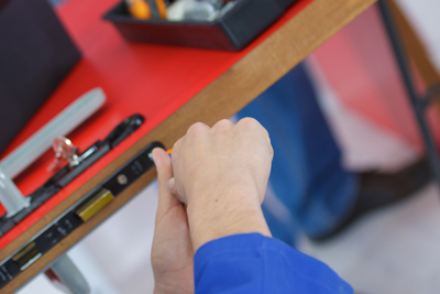person working with tools on a red table hands on tools and equipment related to 13 useful techniques